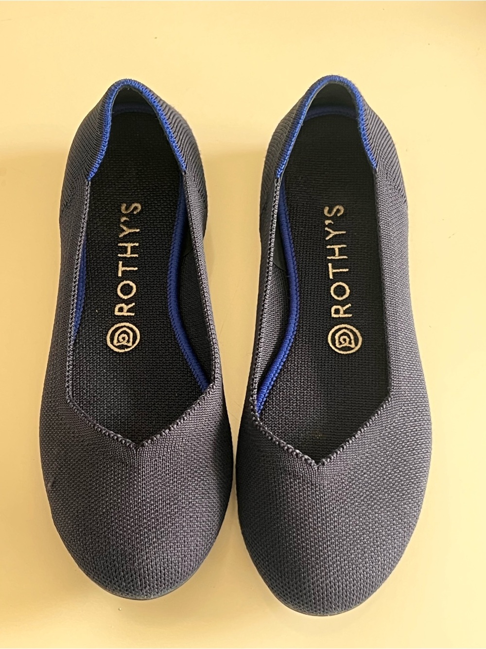 Rothy's navy blue round-toe knit flat shoes featuring a distinctive bright blue - Picture 9 of 12